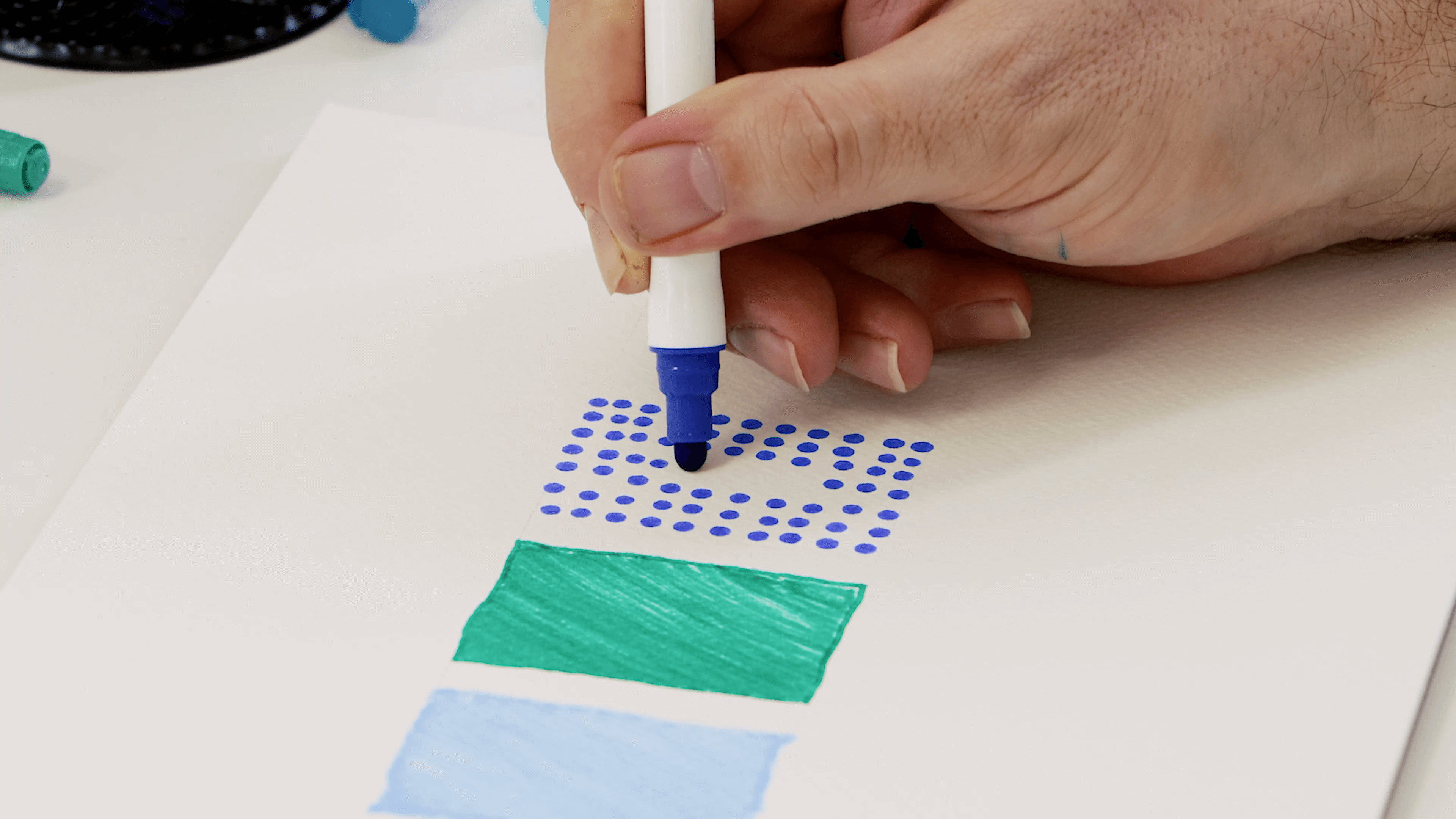 Hand holding a dot marker to show the nib shape on paper.