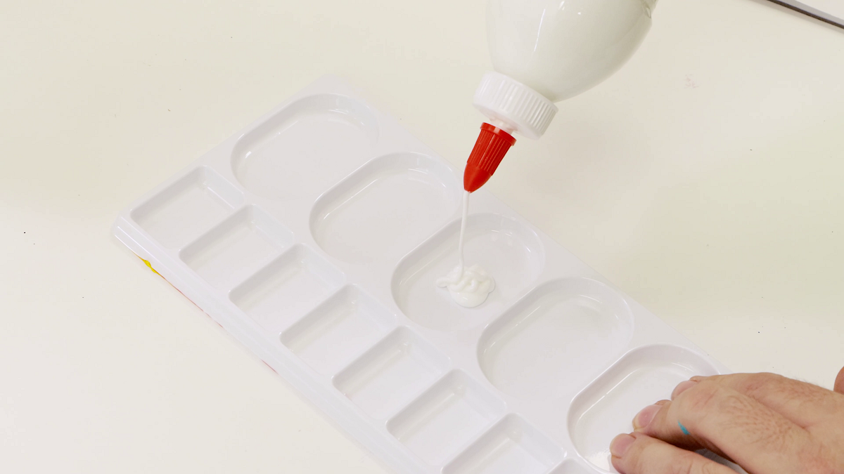 PVA glue being squeezed out onto a white disposable palette.