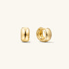 Chunky Huggie Hoops: A pair of thick, gold hoop earrings with a clicker closure, designed for comfort and secure stacking.