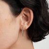 Bezel Lab Grown Diamond Tennis Earrings on a woman's ear, showcasing the elegant 14k solid gold and sparkling lab grown diamonds.