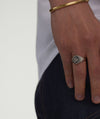 Person wearing the Victory Signet Ring, featuring wing-inspired design symbolizing strength and agility, showcased on their finger as a fashion accessory.