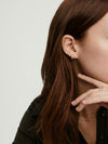 Droplet Lab Grown Diamond Stud: Close-up of a woman's ear adorned with two linked lab-grown diamonds, showcasing elegant movement and refined sparkle.