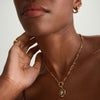 Close-up of a woman's neck wearing a handcrafted 14k gold Triple Link Paperclip Chain Charm Necklace.