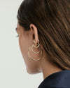 Close-up of a woman's ear adorned with Tube Huggie Hoops, showcasing bold, lightweight design with a secure clicker closure for comfort.