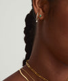 Close-up of a woman's ear wearing a Single Duo Diamond and Emerald Flat Back Stud in 14k solid gold, showcasing the elegant design.