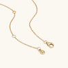 Lotus Necklace: a close-up of a gold chain with a clasp, showcasing its delicate links and versatile design.