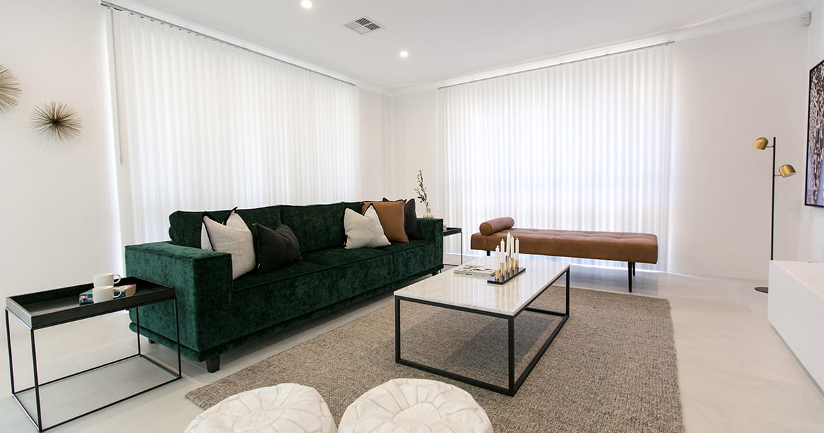Living room with a green couch and white sheer curtains