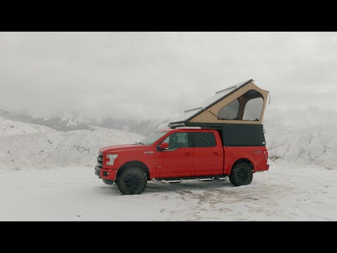 Pick up truck in snow with Lone Peak Camper deployed