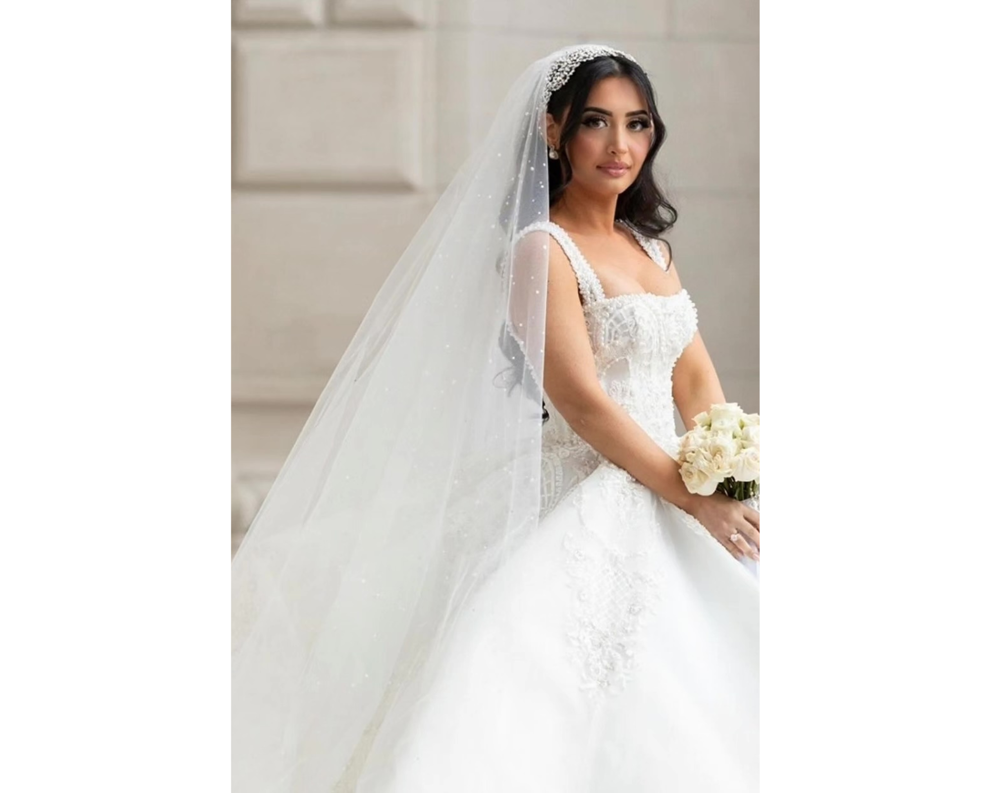 A beautiful bride in her gown with her hair down wearing her pearl and crystal hair vine headband and cathedral veil accented with pearls and crystals.