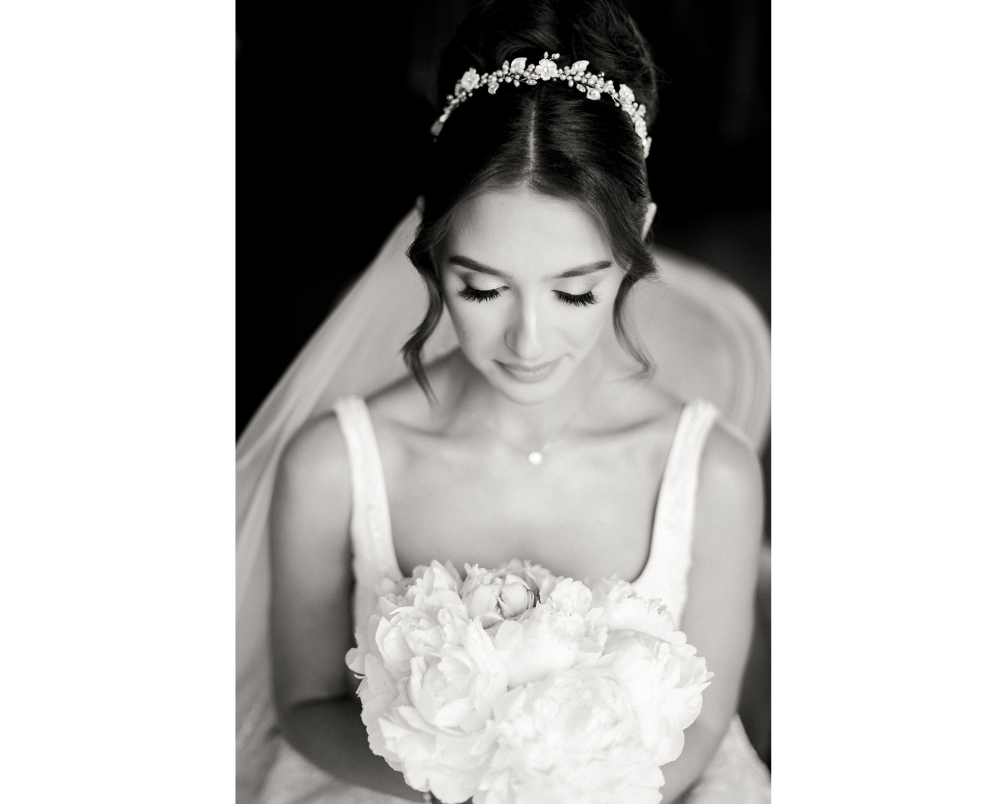 A beautiful black-and-white photo of Kara dressed and ready for her big day! Kara is wearing her bridal headpiece with Swarovski crystals, freshwater pearls, and porcelain flowers. She's also wearing a crystal-edged veil, and pearl and crystal earrings.