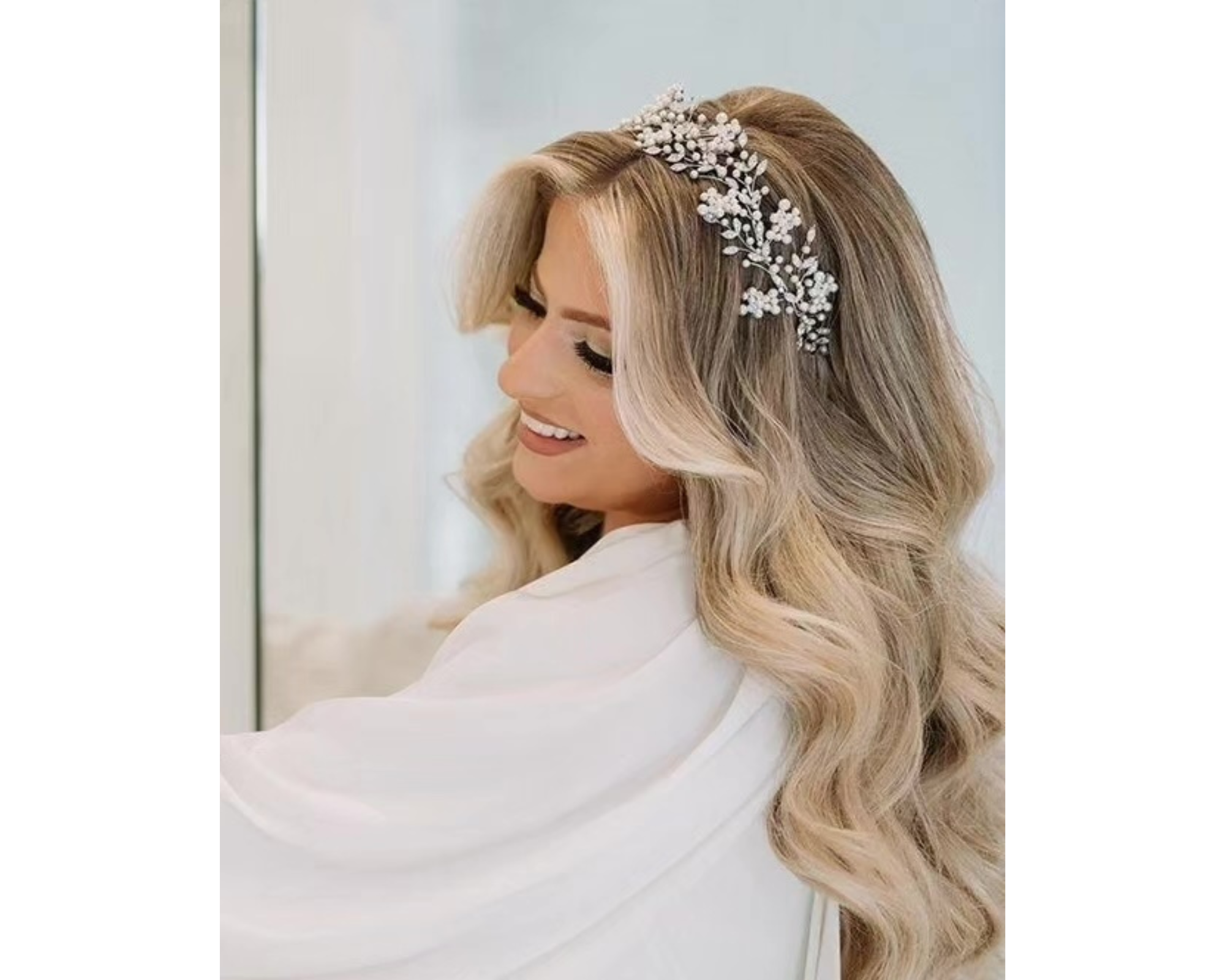 A lovely blonde bride with her long hair in  soft, romantic waves and wearing a sparkling Swarovski crystal bridal headband.