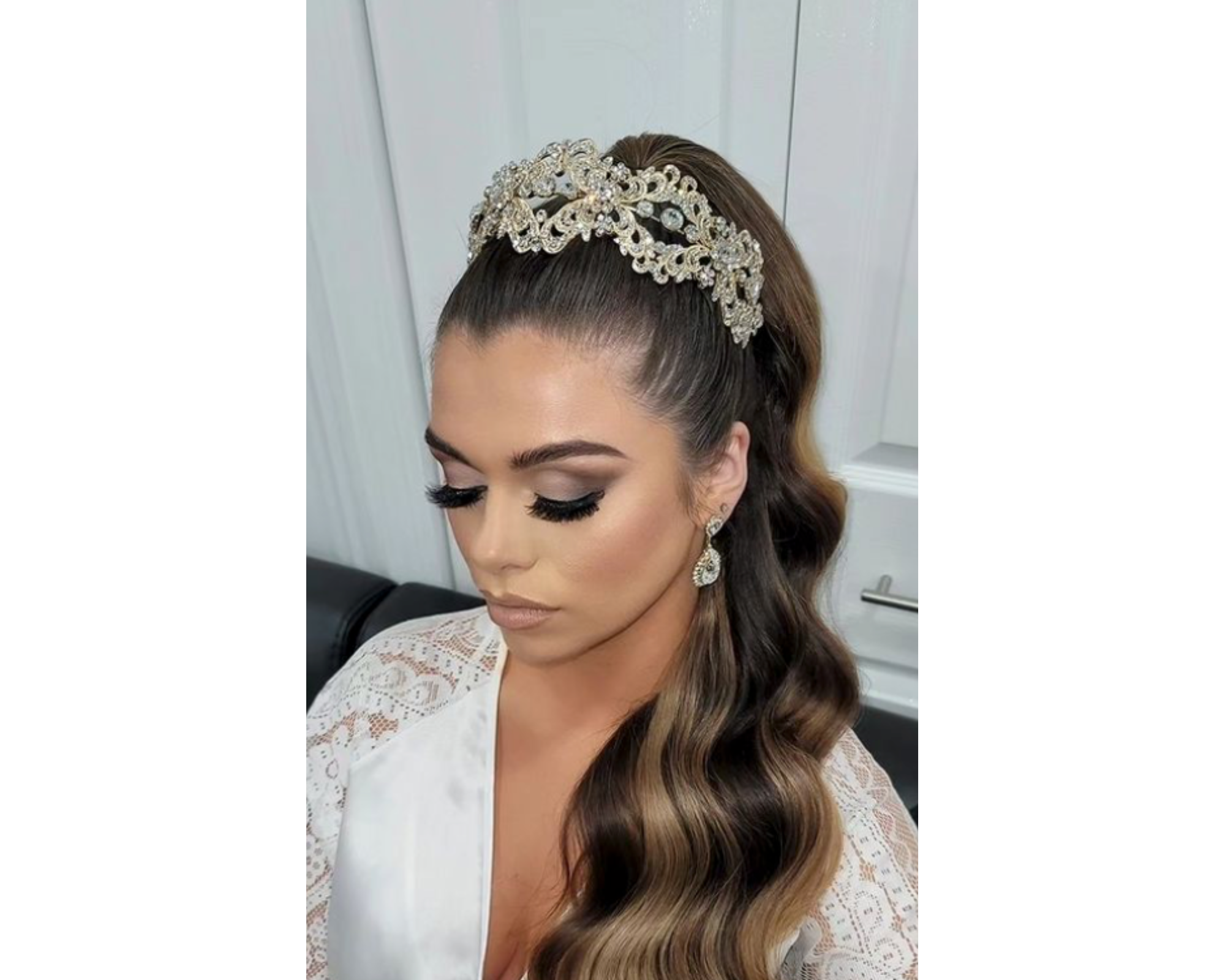 A beautiful bride wearing her hair in a pony tail and crowned with a gold and crystal bridal headband.