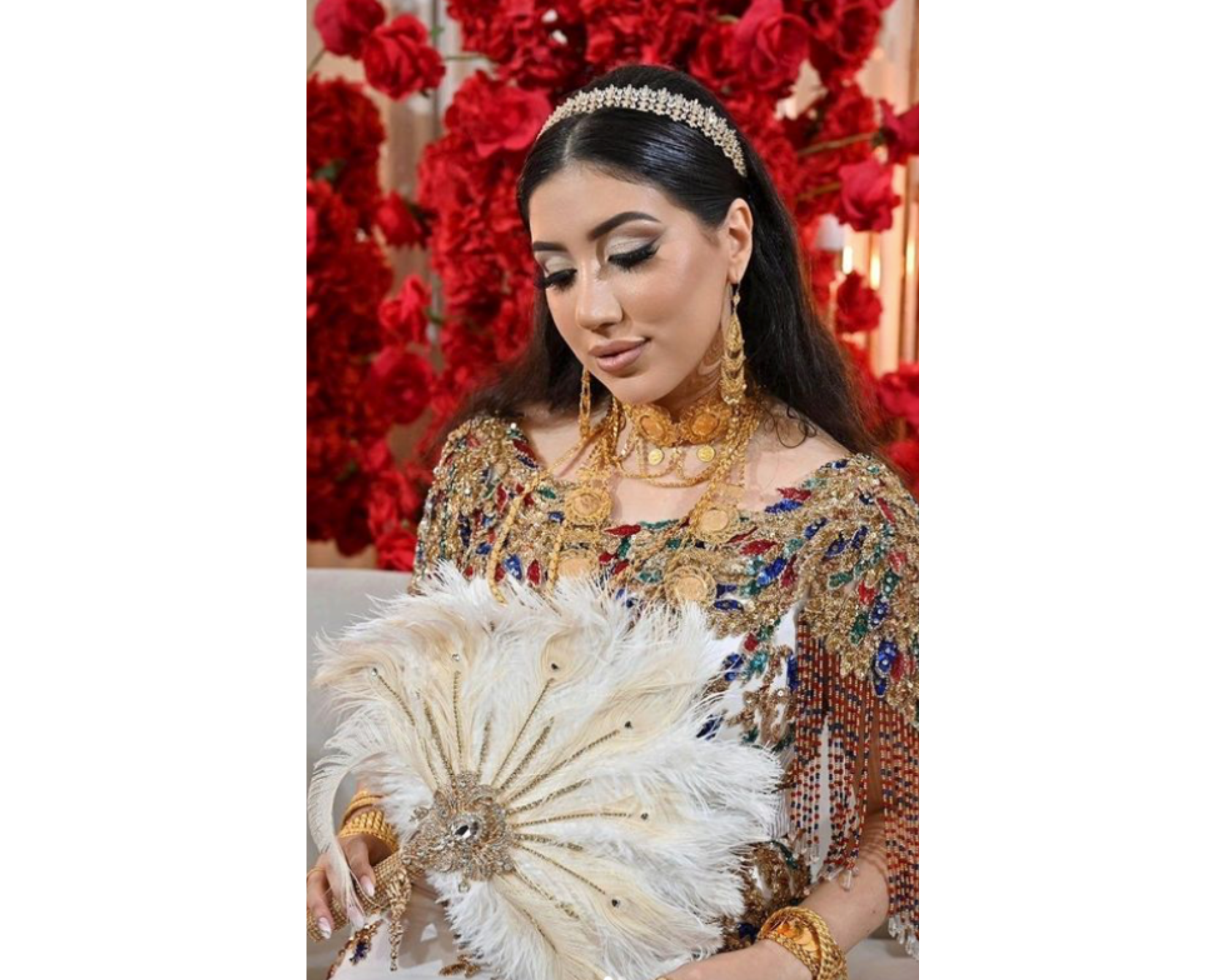 A lovey bride wearing a red and gold gown with a dainty gold and crystal headband