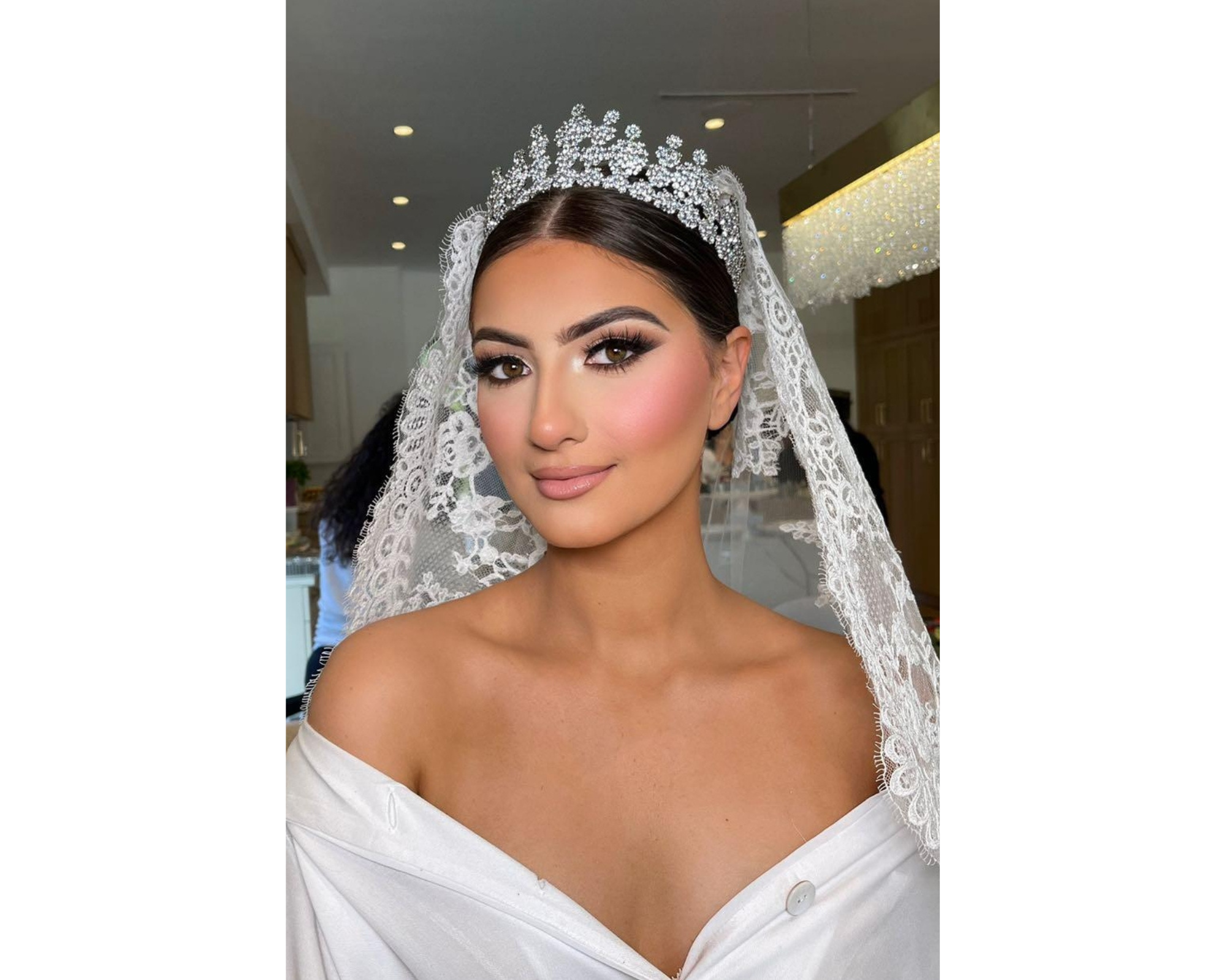 A regal bride wearing her Swarovski wedding tiara , lace cathedra veil, and  lace wedding gown.