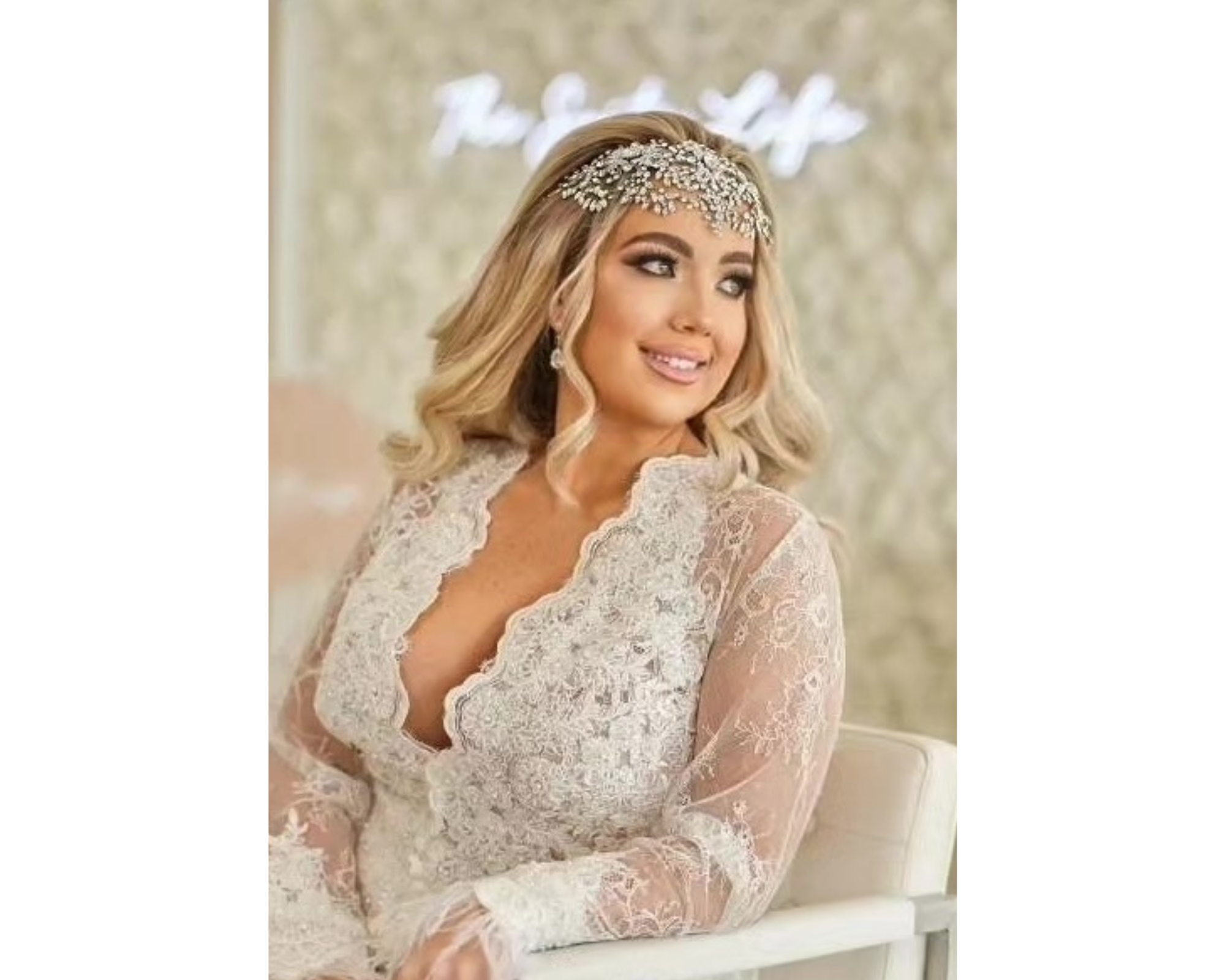 A beautiful blond bride wearing a lace robe and statement crystal bridal headpiece.