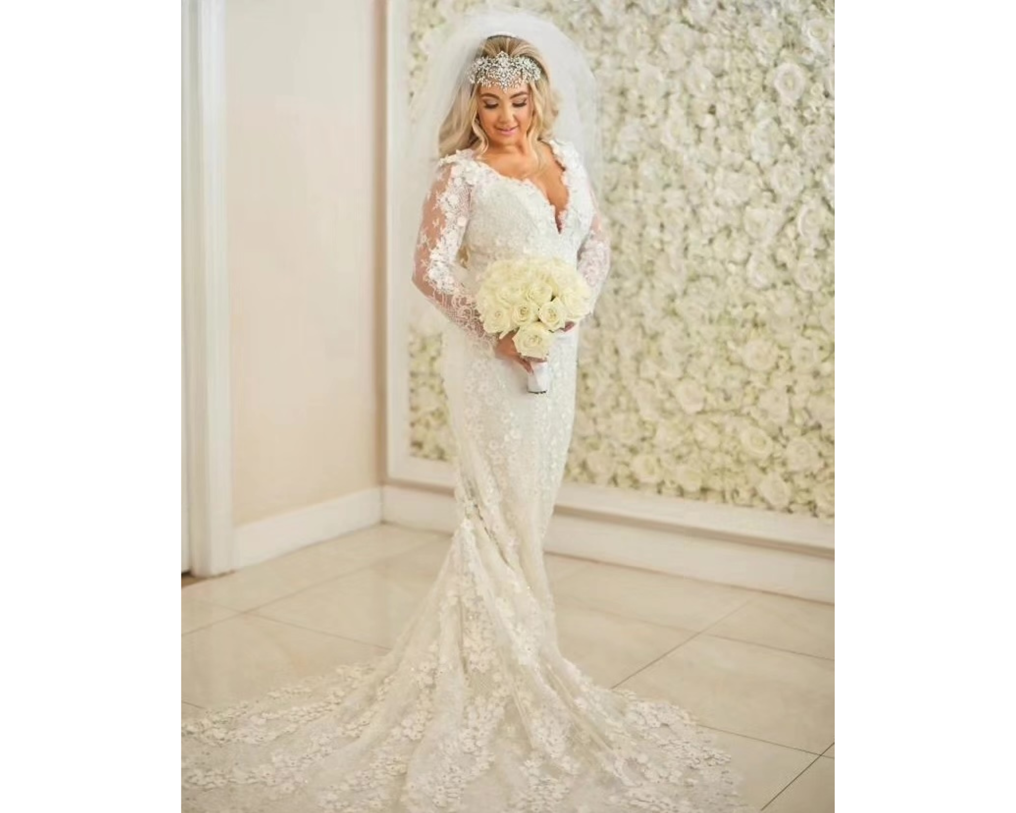 A beautiful blond bride holding her bouquet. She’s wearing a lace wedding dress and crystal bridal headpiece.