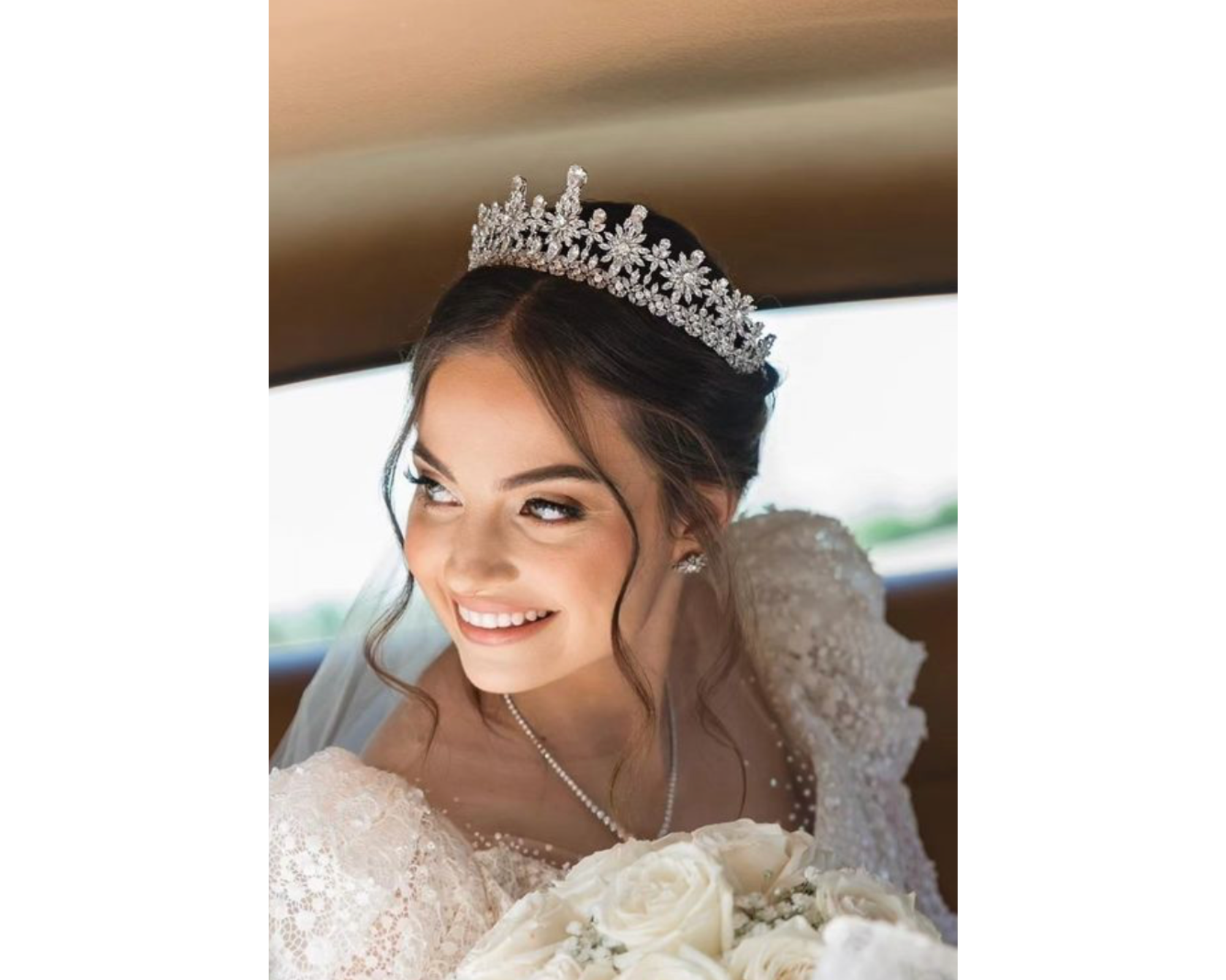 A beautiful bride leaning forward in her limo and wearing a delicate Swarovski crystal tiara.