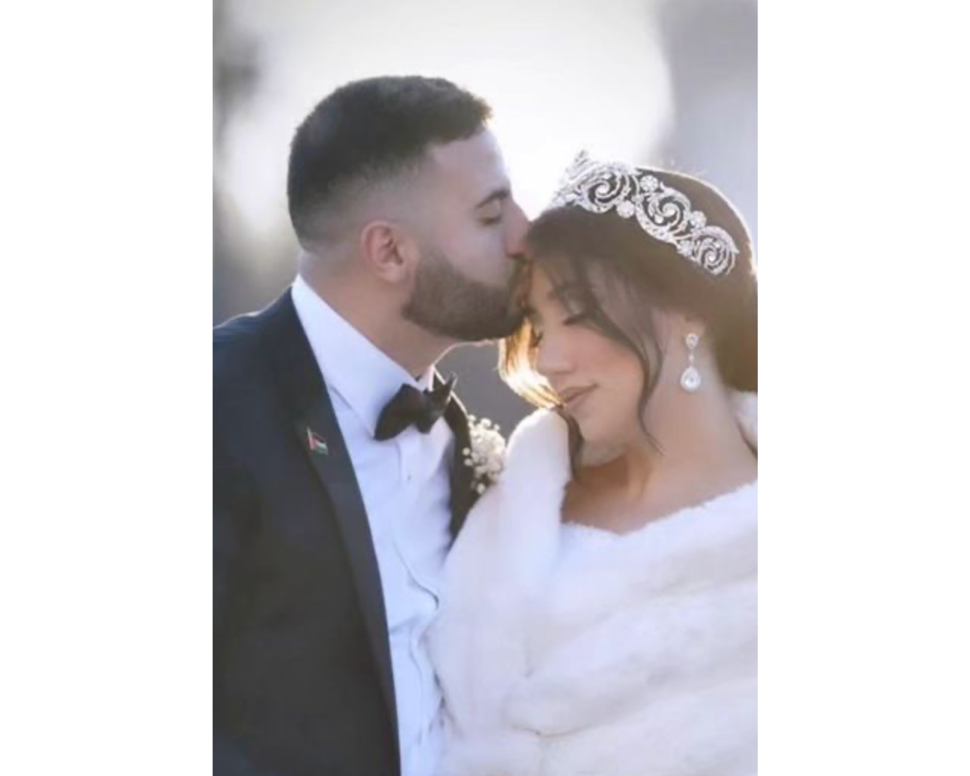 A beautiful winter bride with her groom   wearing a dazzling regal tiara and faux fur wrap.