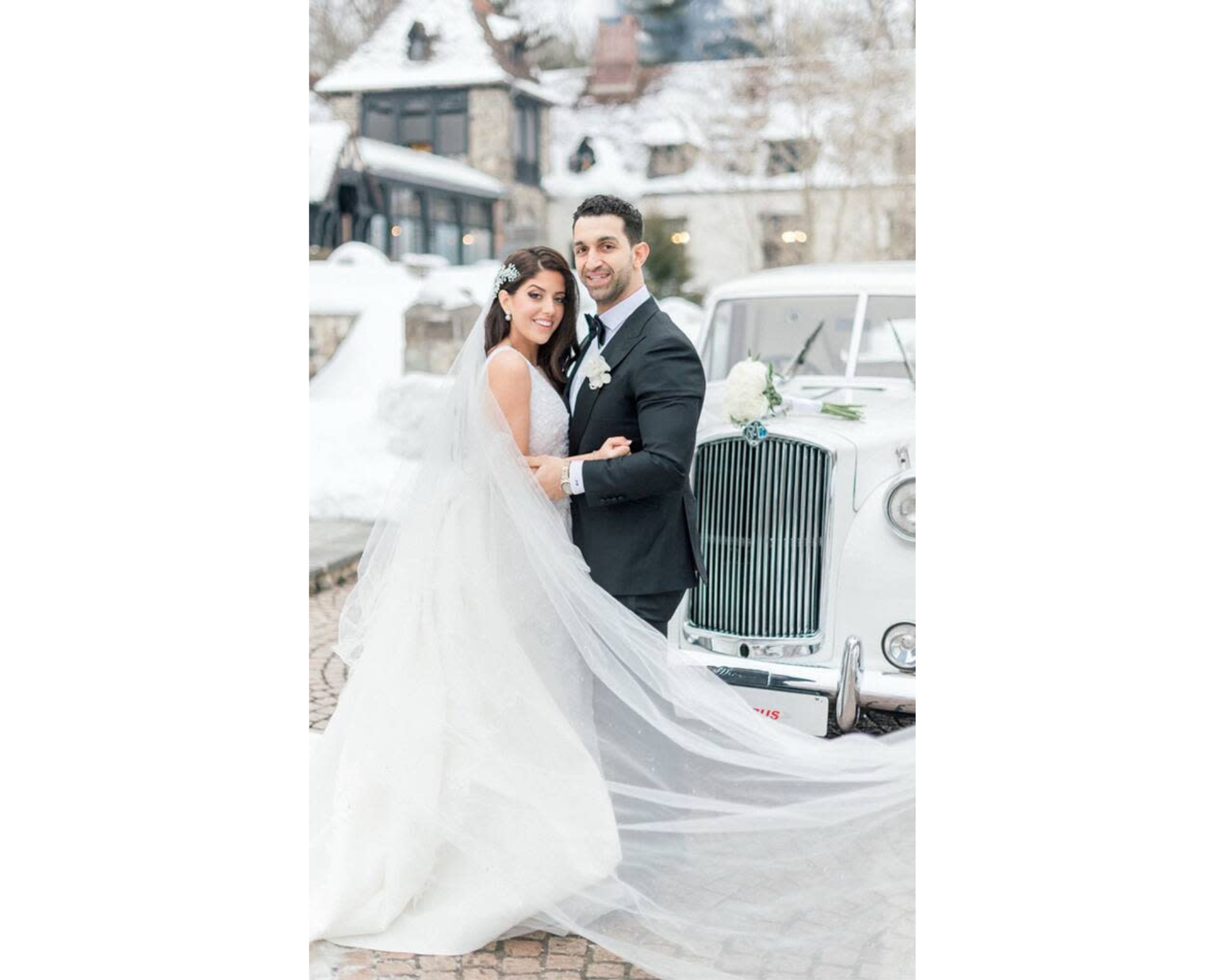 Our bride Victoria and her groom Teddy standing in front Rolls Royce on their snowy wedding day.