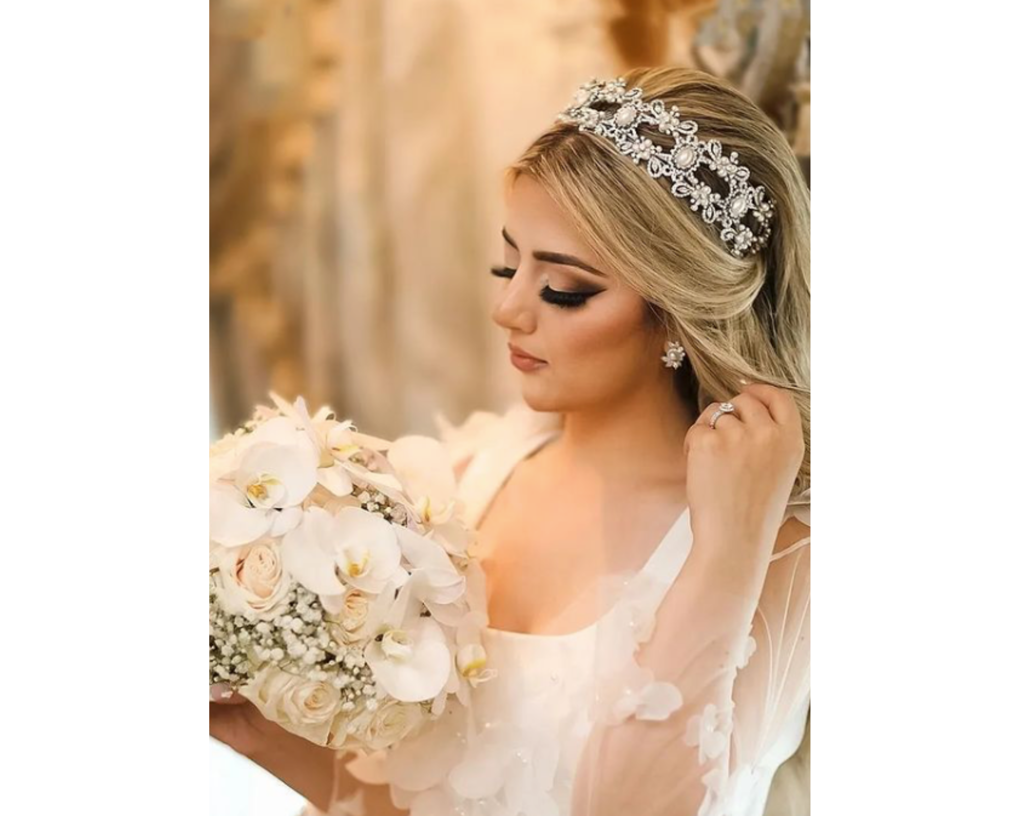 A beautiful bride wearing an ornate pearl and crystal wedding headpiece with pearl drop earrings