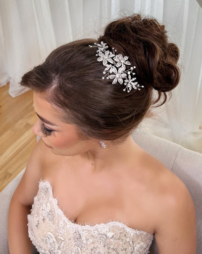 female model wearing silver bridal hair comb with crystalized flowers and small sprigs of crystal with an updo