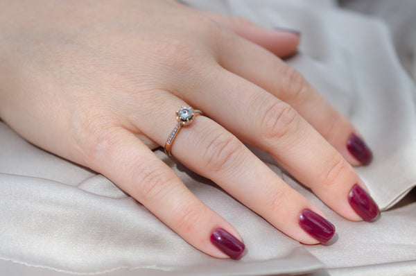 close up shot of hand of a woman with wine red nail polish and engagement ring