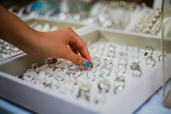 person's hand picking a ring from a starter kit of assorted fashion rings