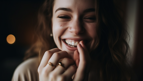 smiling woman wearing gold-plated minimal fashion rings