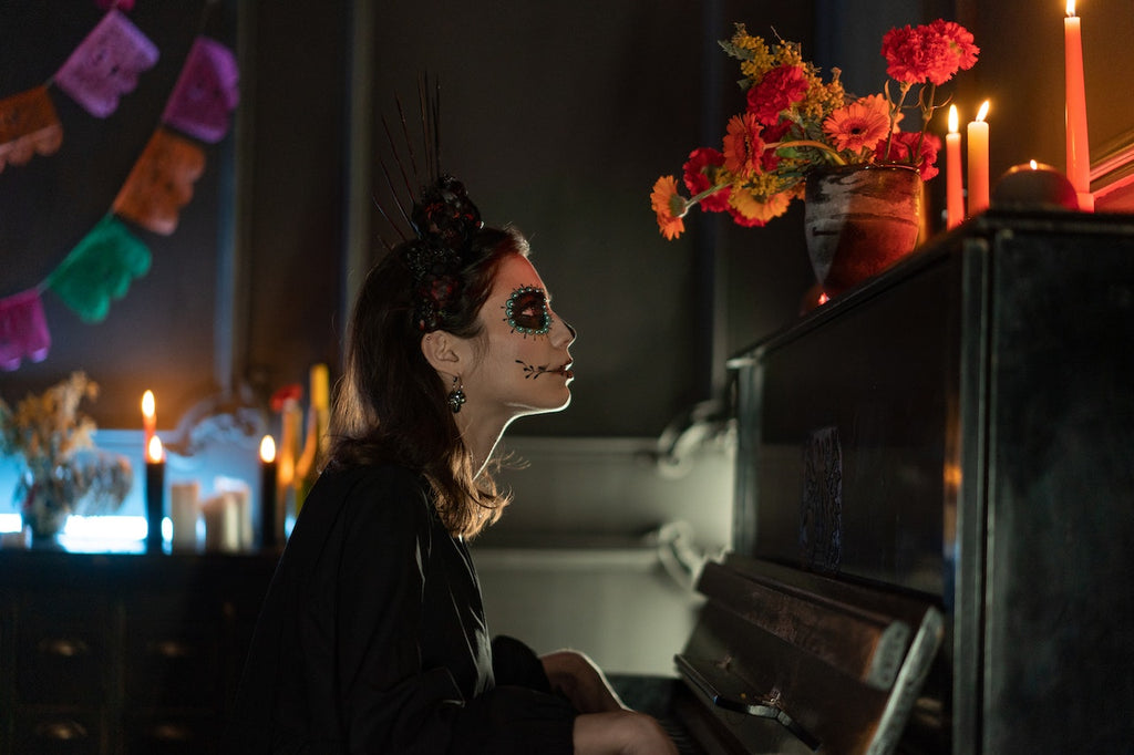 woman with skeleton face makeup looking at lighted candles