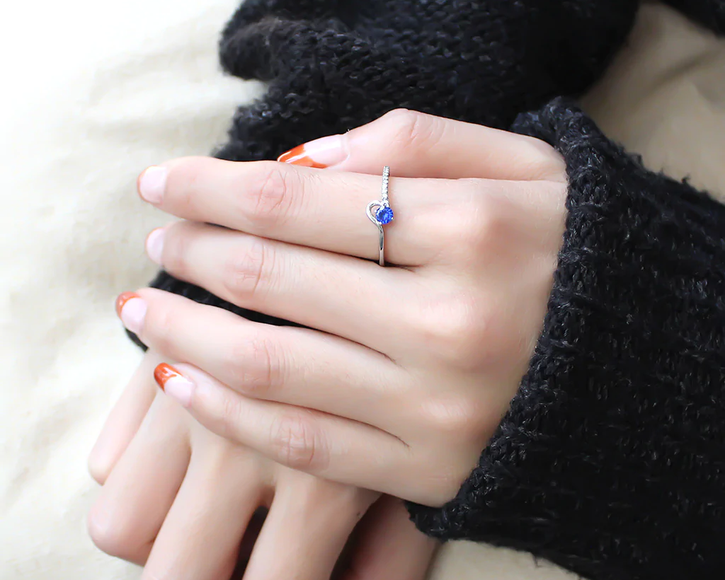 woman's hand wearing london blue solitaire ring from cerijewelry