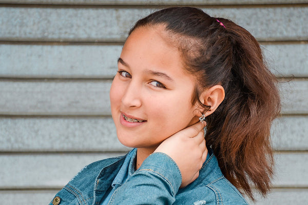 young lady in a ponytail wearing minimalist earrings