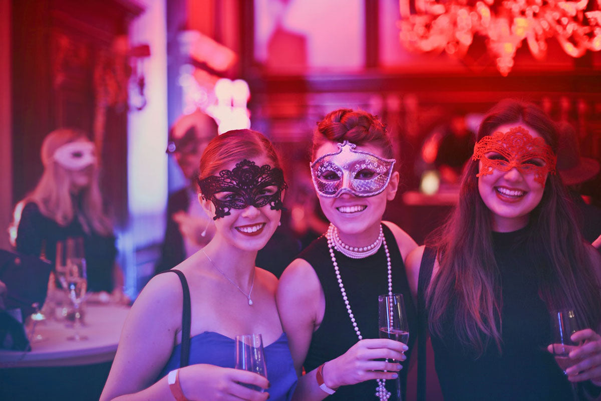 Women at a party wearing masquerade masks