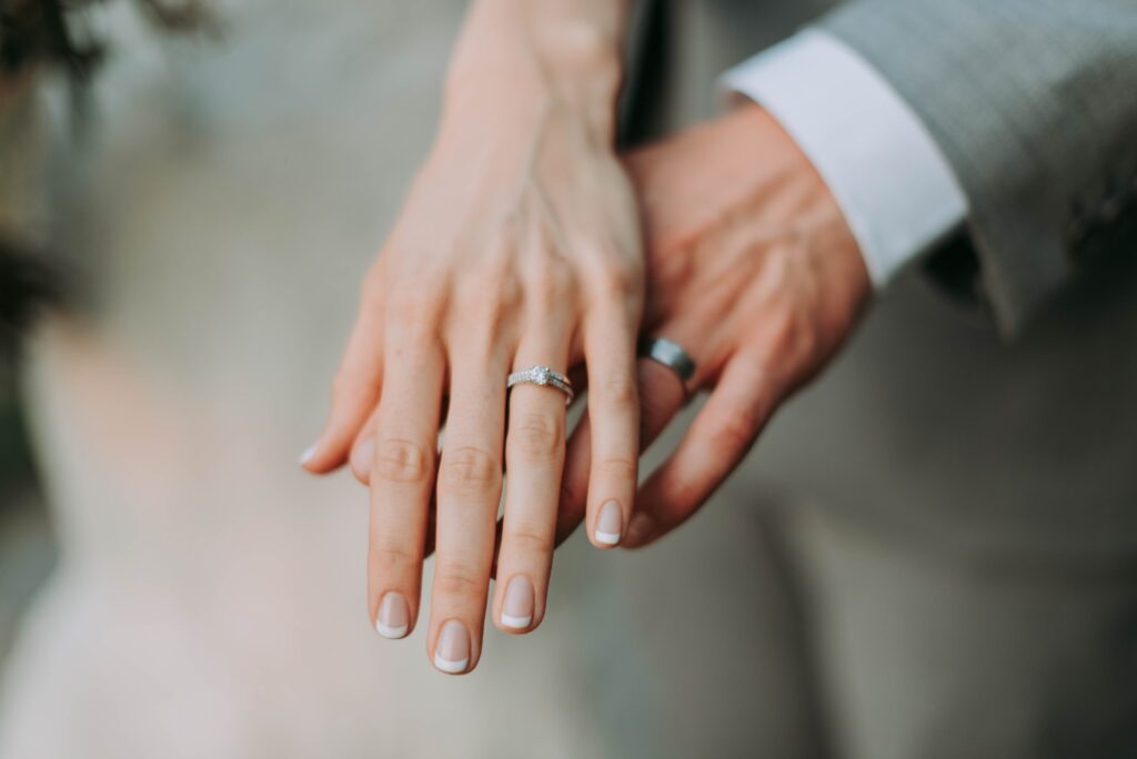 hand of woman with an engagement ring touching hand of man
