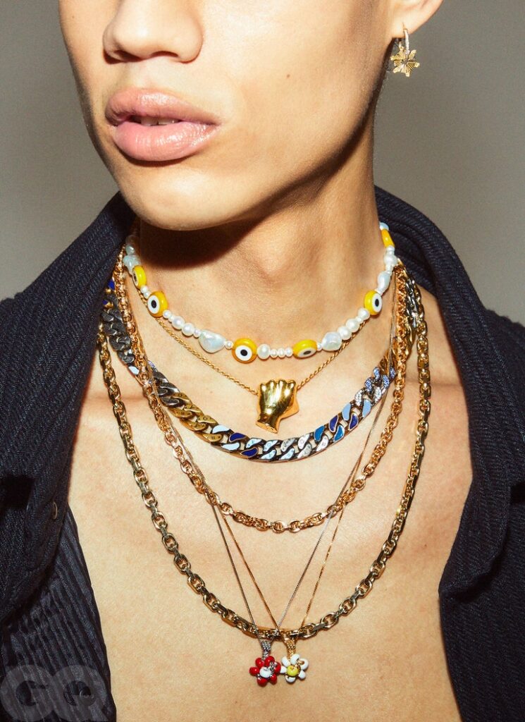 model wearing a charm earring and layers of necklaces