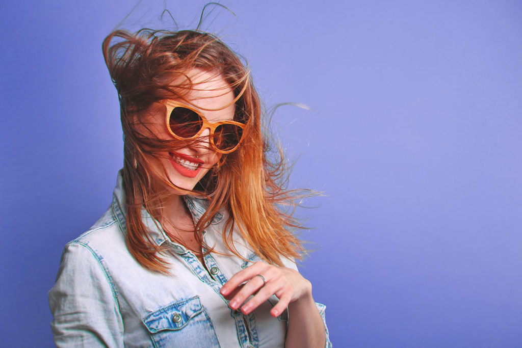 Smiling woman wearing a pair of sunglasses and a ring