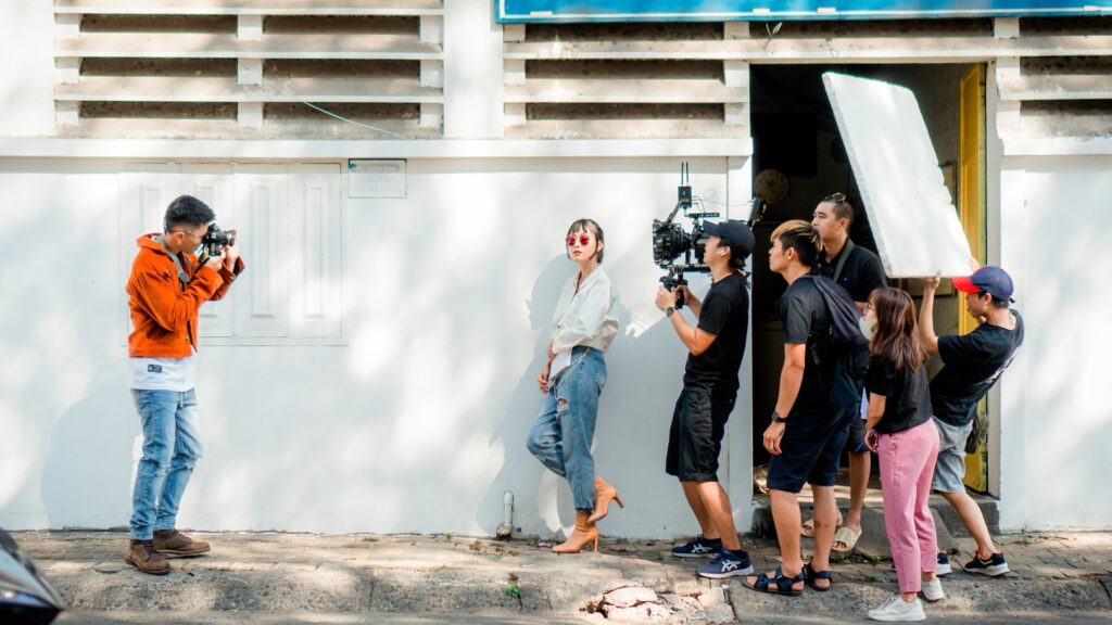 people filming a woman wearing fashion jewelry on set