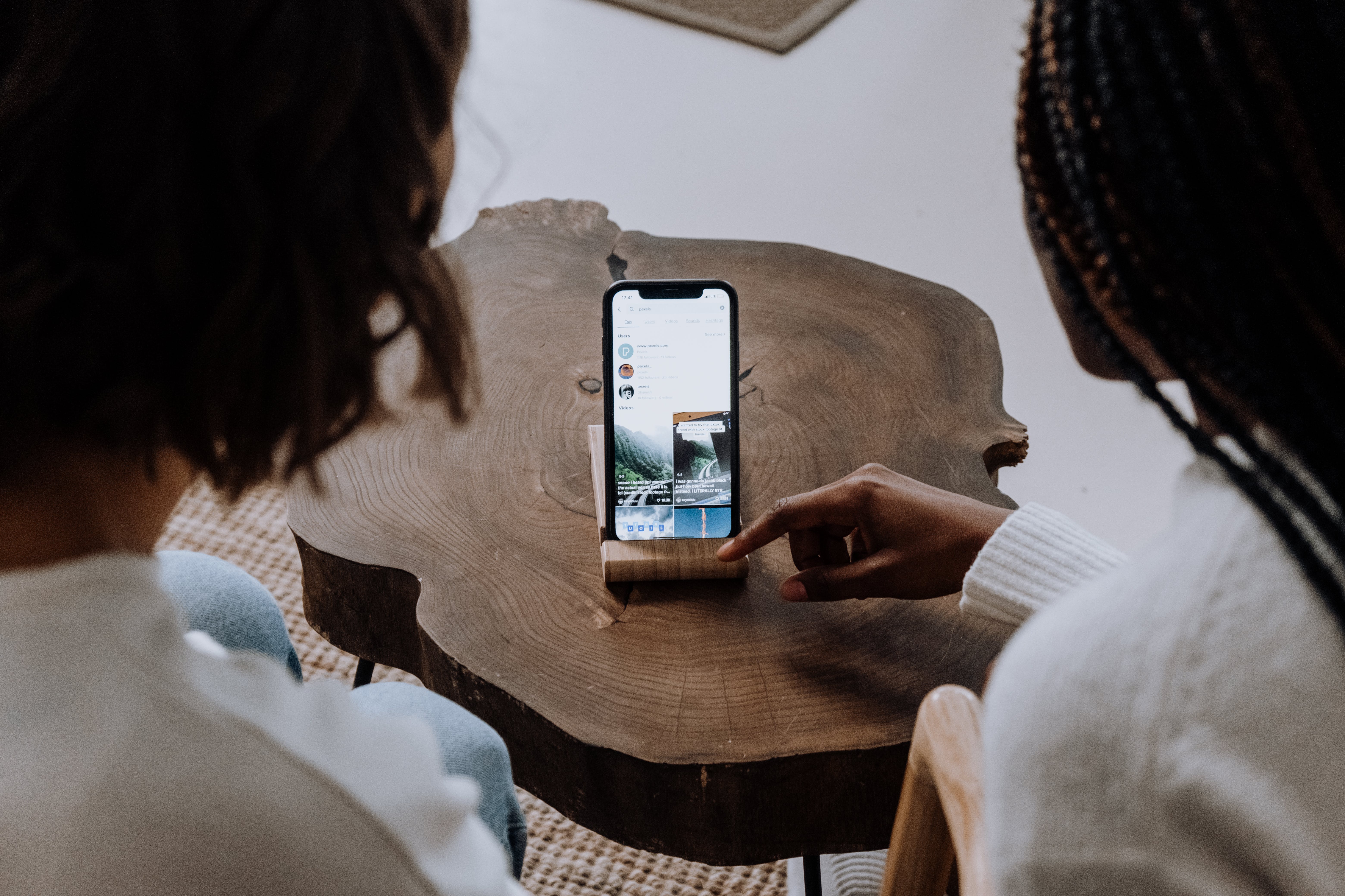 two women checking out TikTok on a smartphone