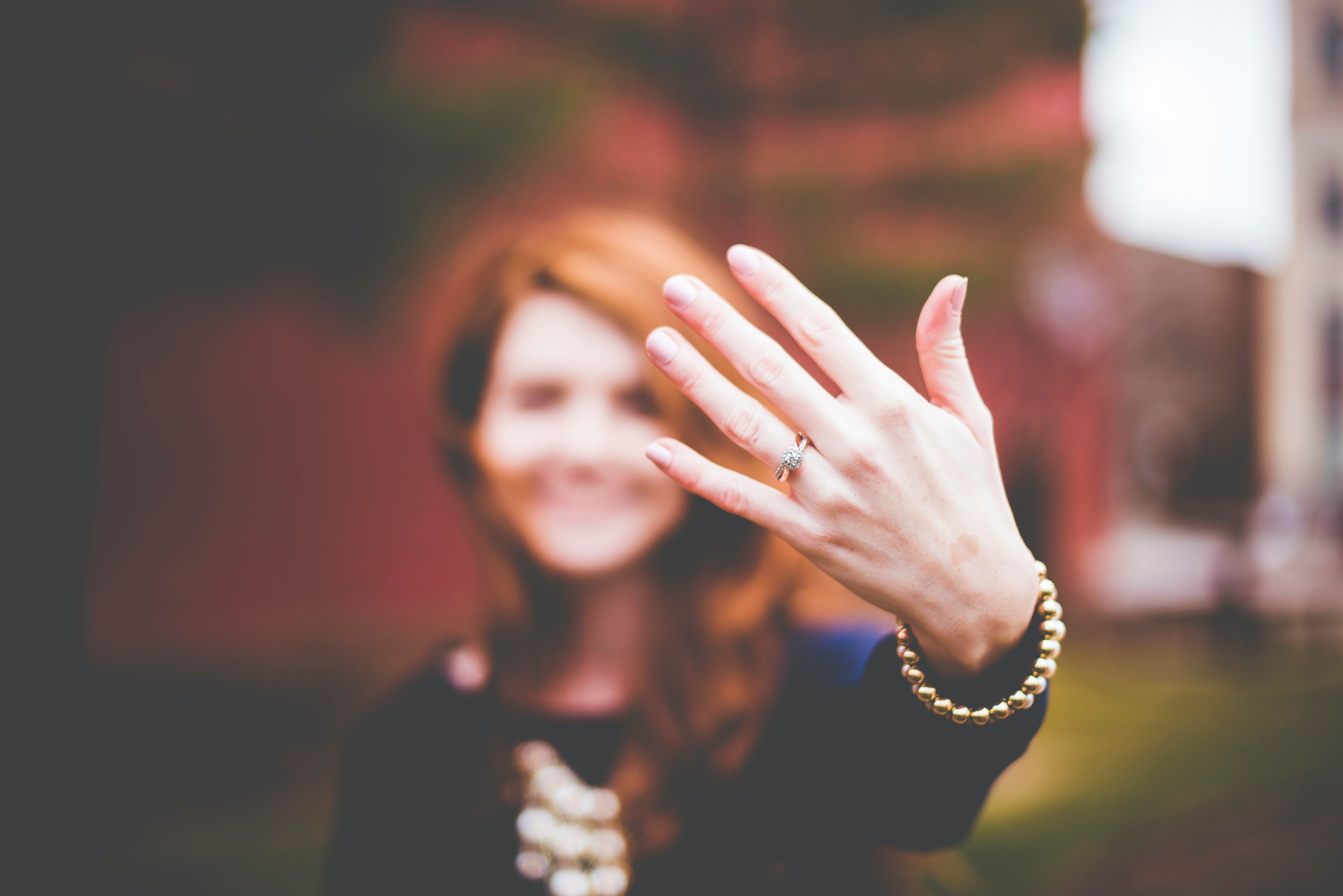 blurred photo of woman showing off her wedding ring