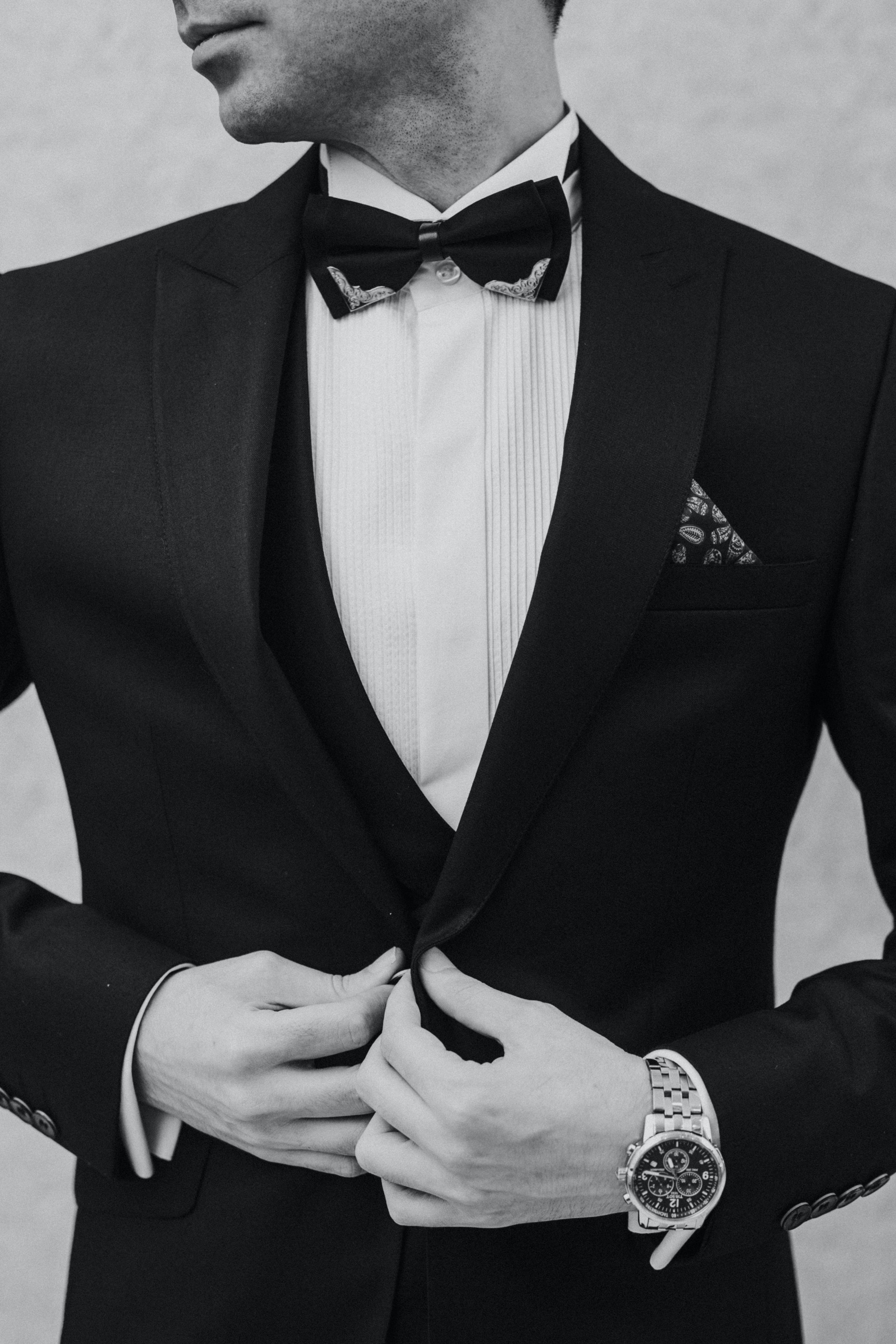 black and white photo of a man wearing a suit with black bowtie