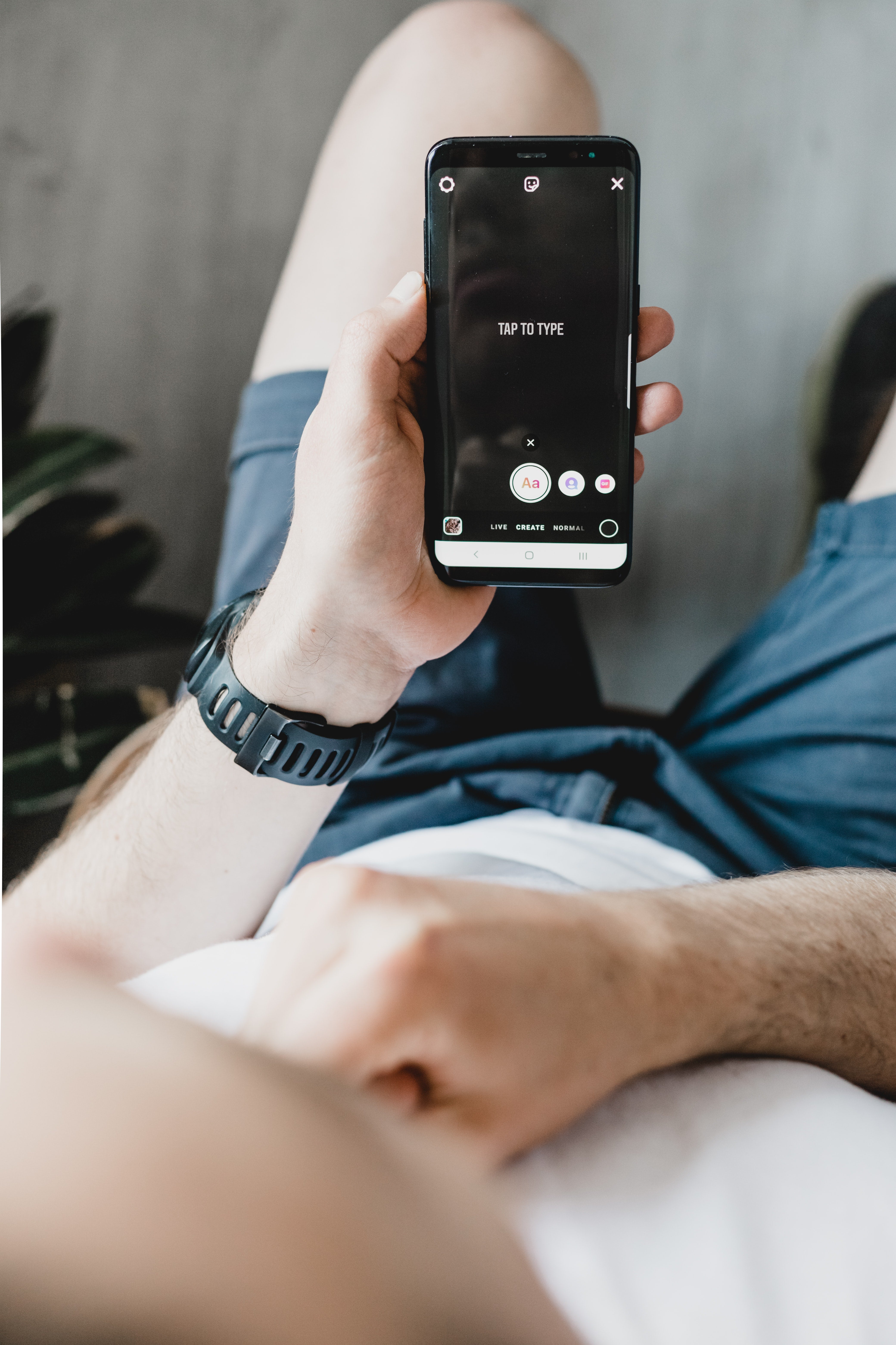 man holding smart phone about to upload on Instagram Stories