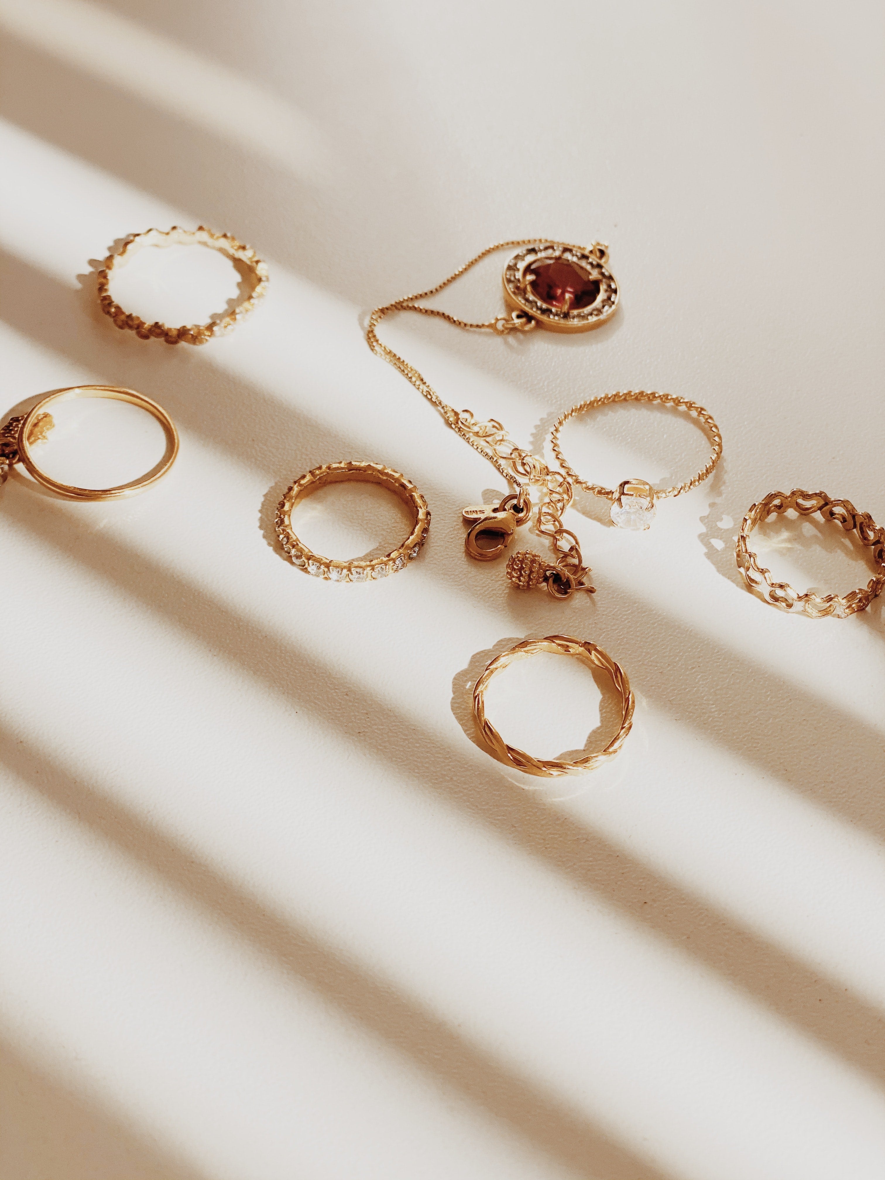 fashion rings and a necklace on a white surface