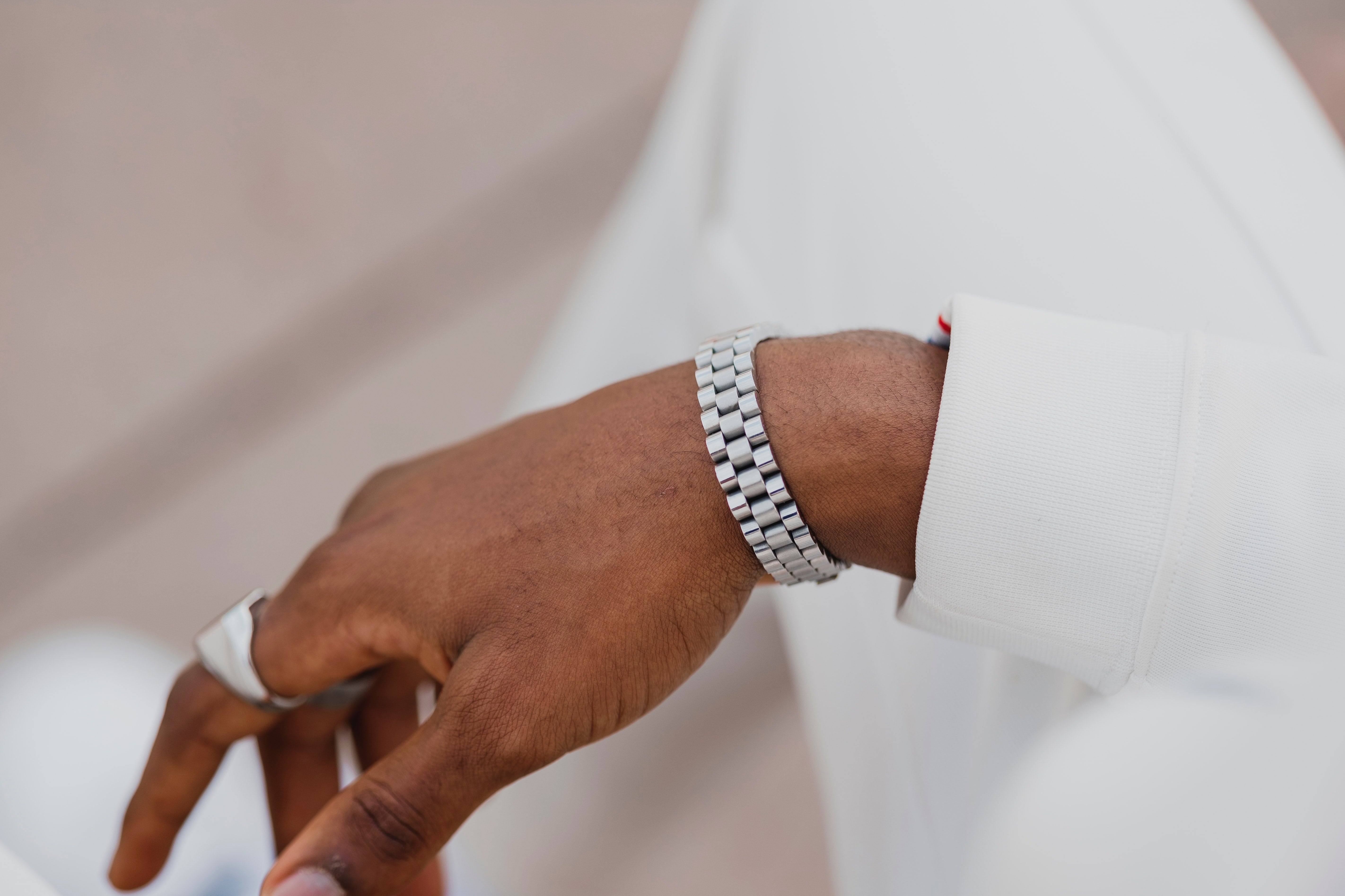 man's hand with stainless steel ring on index finger and watch on wrist