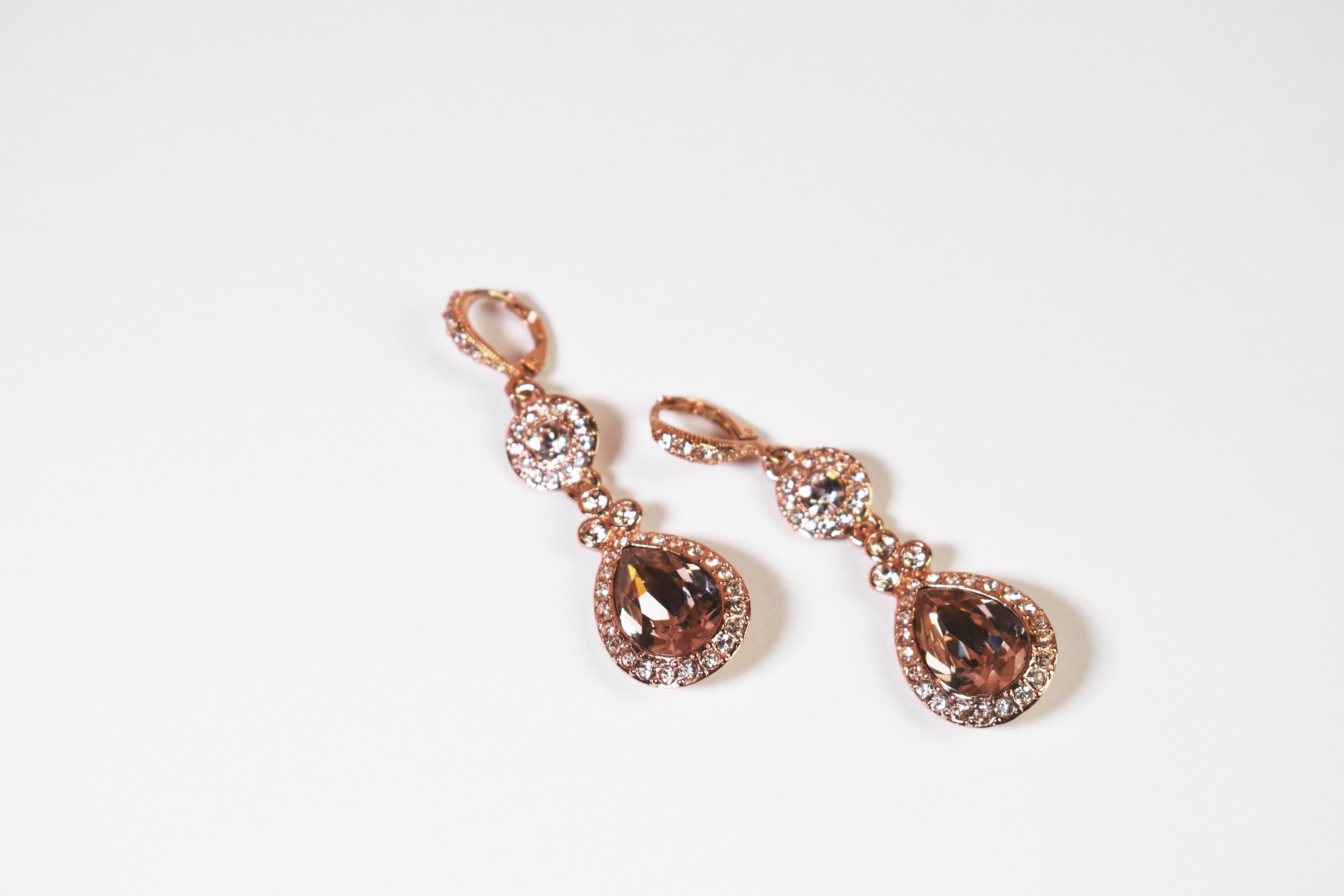 rose gold drop earrings with smoky quartz crystals on a white surface