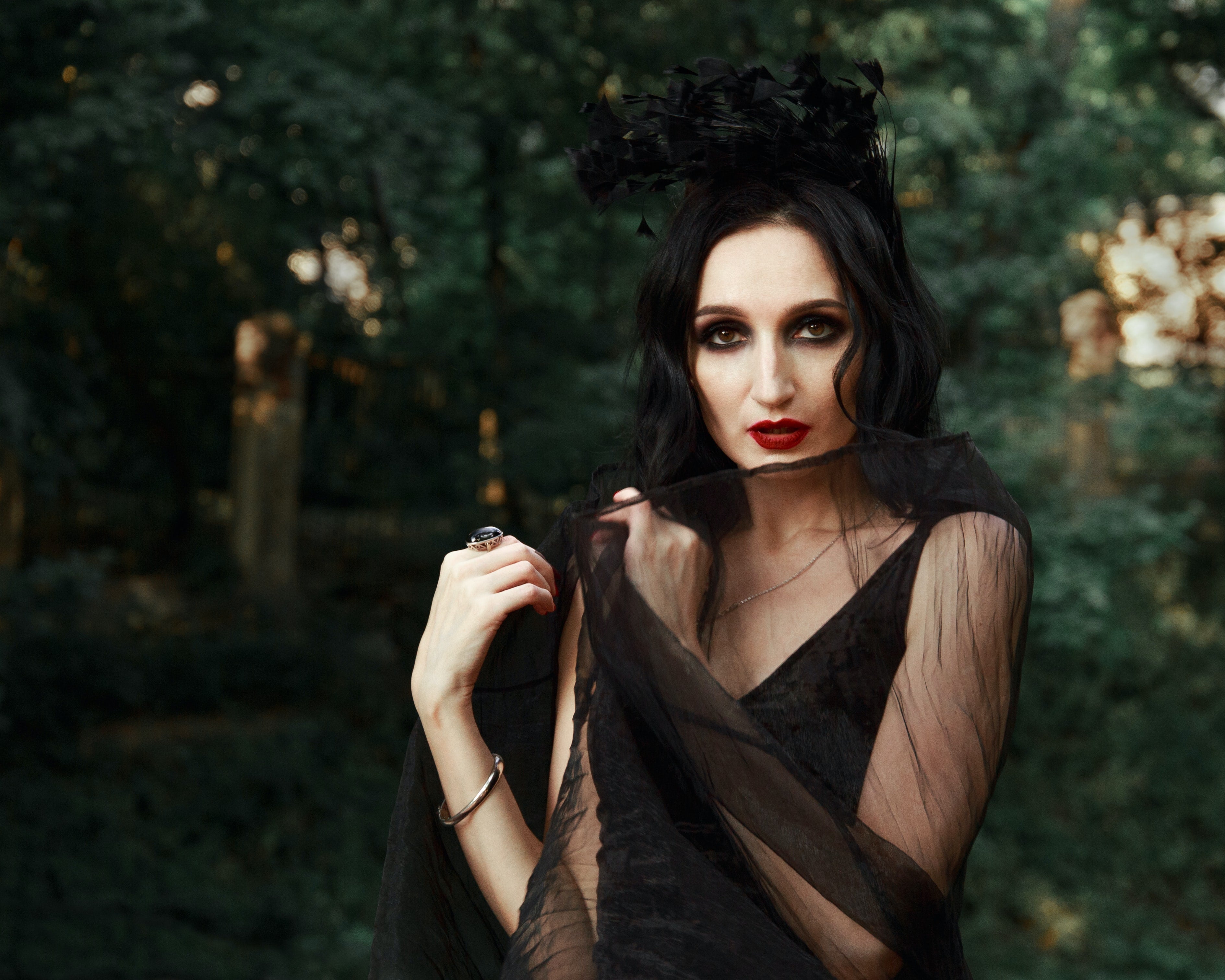 woman wearing black make up, dress, head dress, and fashion ring for Halloween