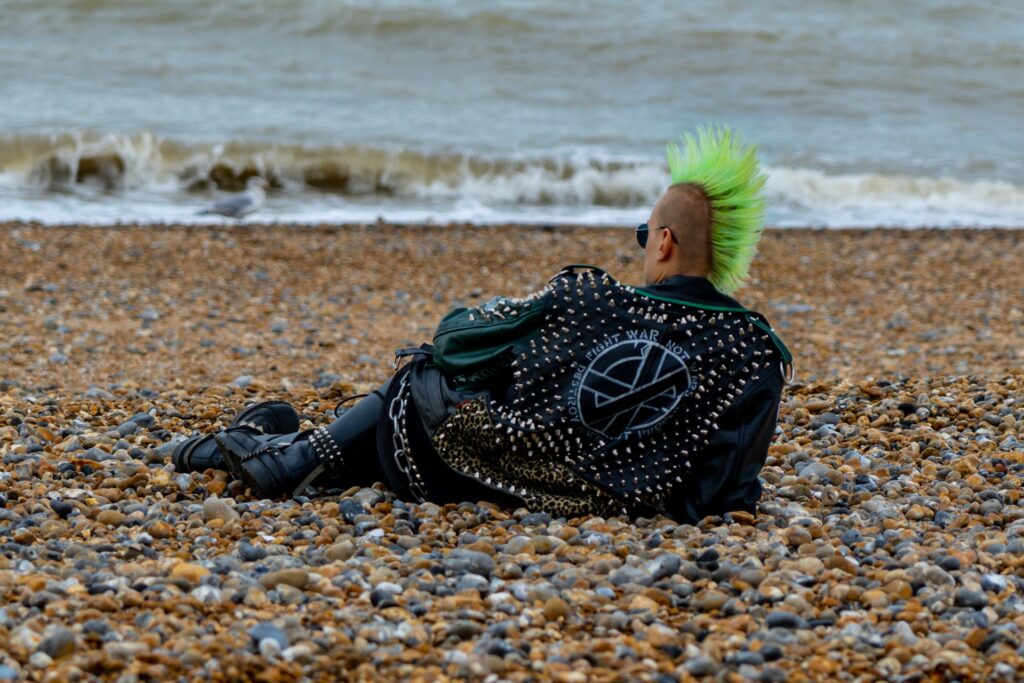 punk rocker in leather with neon green mohawk at the beach