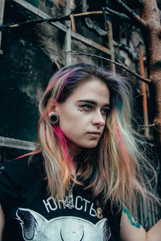 punk woman with brightly colored hair highlights wearing a black shirt