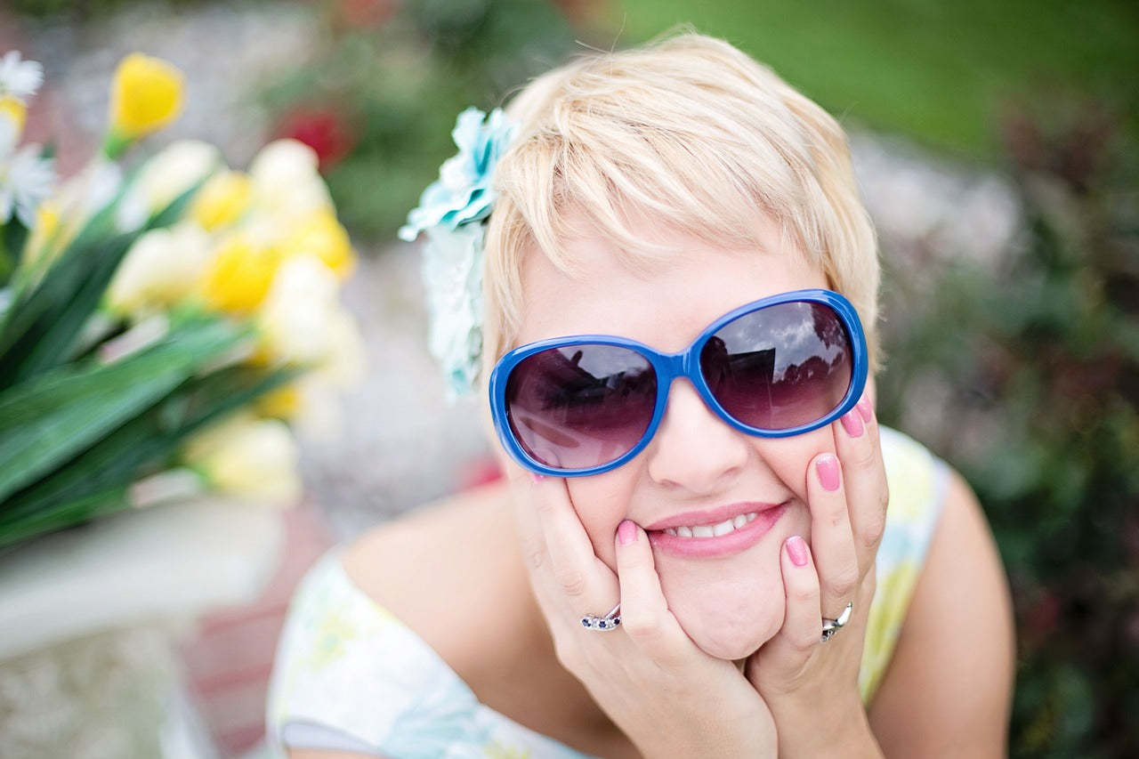 Woman with sunglasses and rings smiling