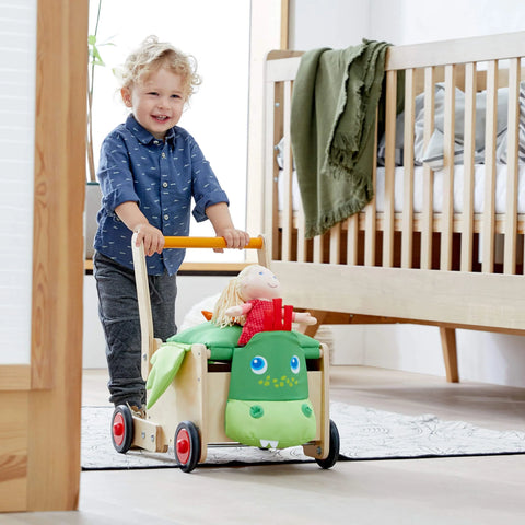 Child pushes HABA Dragon Walker with toys in wagon