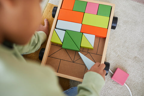 Young girl plays with geometric blocks STEM learning