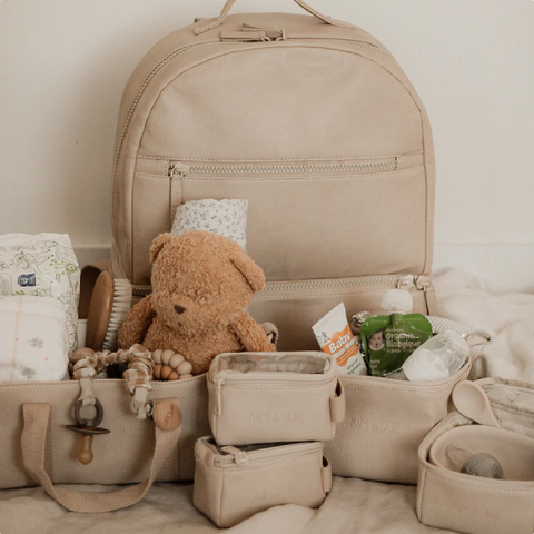 un sac à dos contenant un ours en peluche et d'autres objets